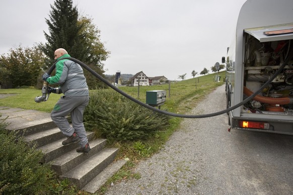 Der Mitarbeiter des Transportunternehmens Traveco AG, Herr Schindler, zieht am 25. Oktober 2007 einen Tankschlauch zu einer Liegenschaft in Winterthur, um im Auftrag des Brenn- und Treibstoffunternehm ...