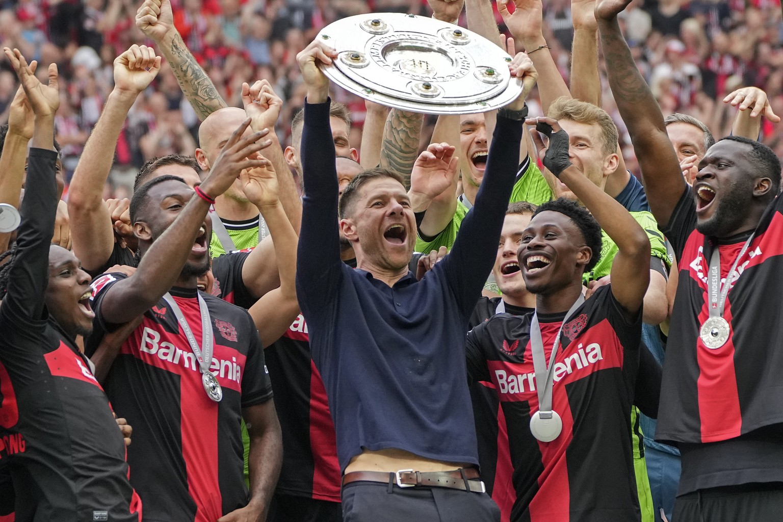 FILE - Leverkusen&#039;s head coach Xabi Alonso celebrates with the trophy as his team won the German Bundesliga, after the German Bundesliga soccer match between Bayer Leverkusen and FC Augsburg at t ...