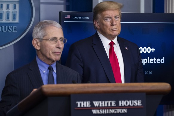 FILE - In this April 17, 2020, file photo Dr. Anthony Fauci, director of the National Institute of Allergy and Infectious Diseases, speaks about the coronavirus, as President Donald Trump listens, in  ...