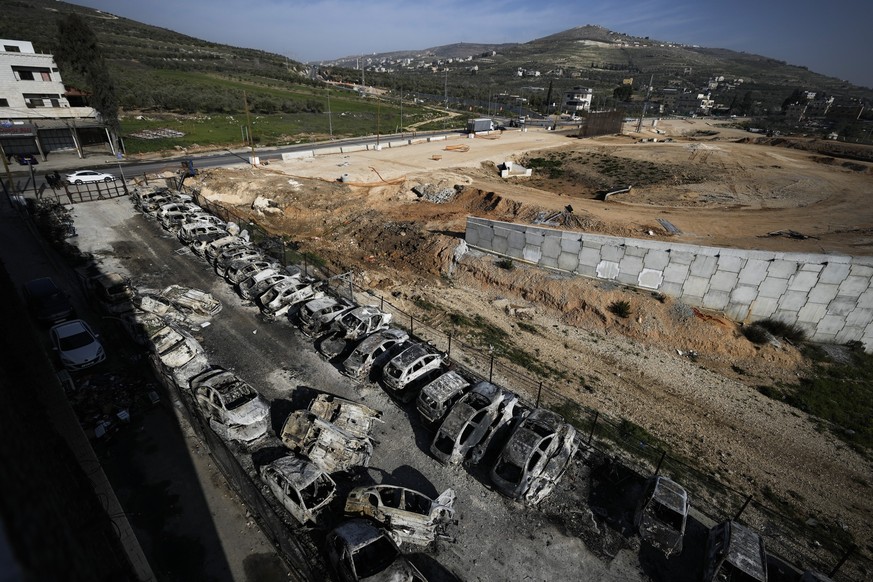 Burnt-out cars can be seen in the town of Huwara, near the West Bank town of Nablus, Monday, Feb. 27, 2023. Dozens of Israeli settlers went on a violent rampage in the northern West Bank, destroying cars and…