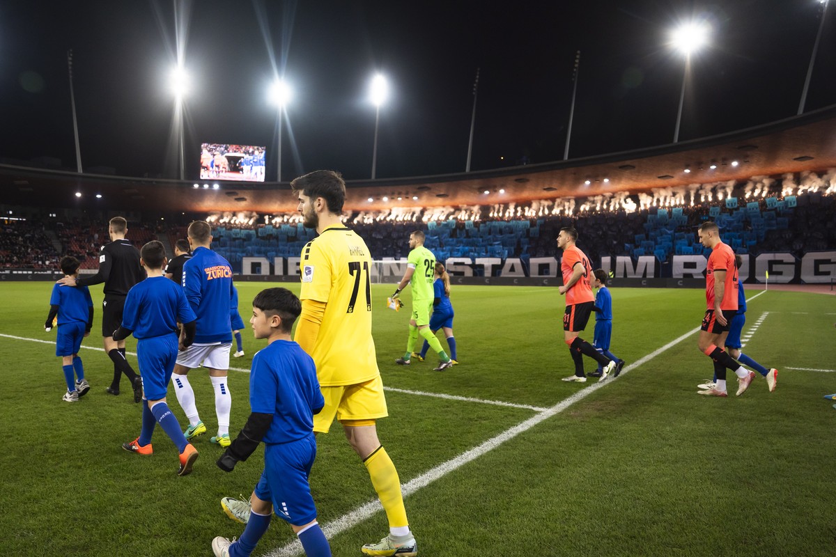 Die Spieler betreten den Rasen im Fussball Cupspiel zwischen GC Zuerich und dem FC Zuerich am Dienstag, 3. Dezember 2024 im Stadion Letzigrund in Zuerich. (KEYSTONE/Til Buergy)