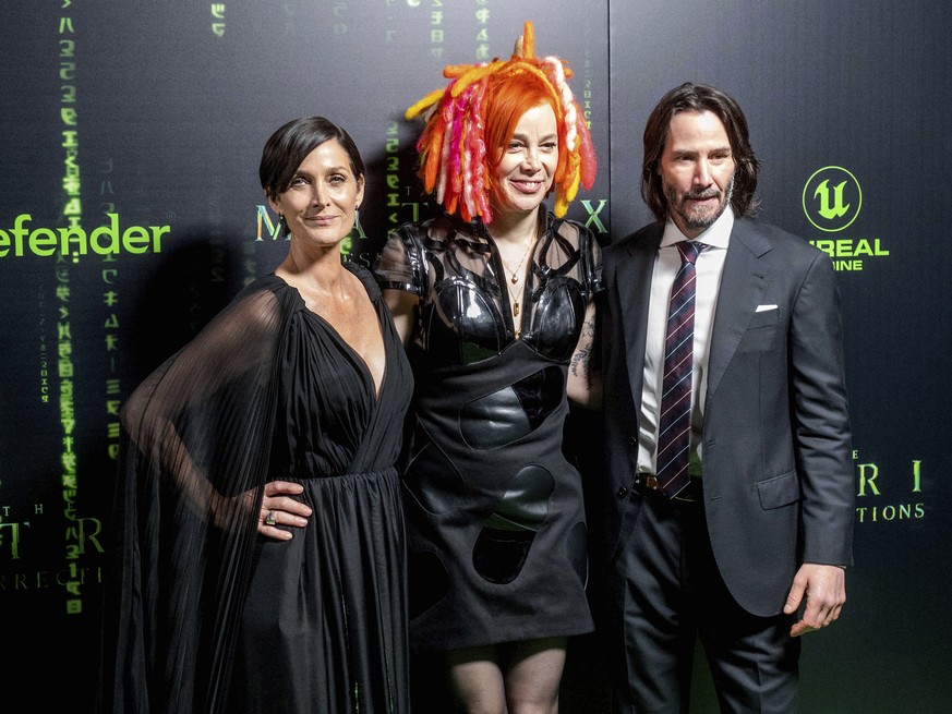 Carrie-Anne Moss, from left, Lana Wachowski and Keanu Reeves arrive at the premiere of &quot;The Matrix Resurrections&quot; on Saturday, Dec. 18, 2021, at the Castro Theatre in San Francisco. (AP Phot ...