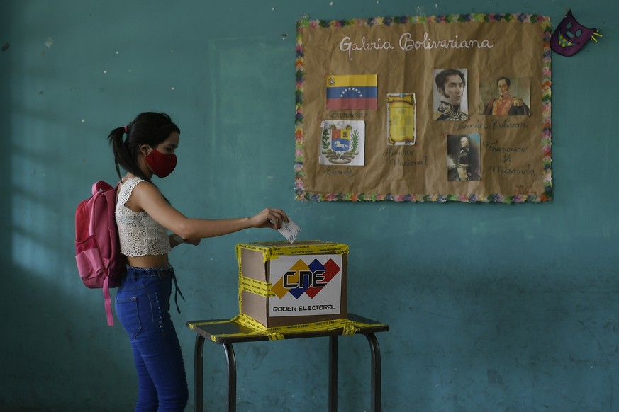 A voter casts her ballot during elections to choose members of the National Assembly in Caracas, Venezuela, Sunday, Dec. 6, 2020. The vote, championed by President Nicolas Maduro, is rejected as fraud ...