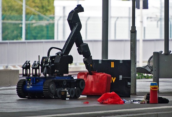 epaselect epa05576507 A remotely controlled bomb disposal robot lifts a red suitcase on a platform in Chemnitz Central Station, eastern Germany, 08 October 2016. A large-scale police operation is unde ...
