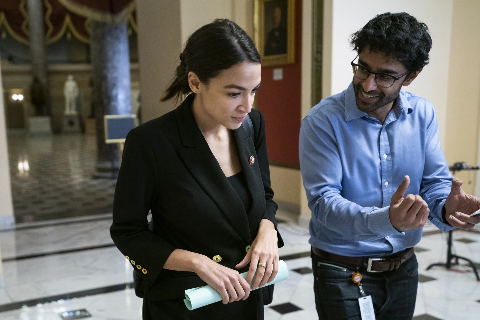epa07371204 Democratic Representative from New York Alexandria Ocasio-Cortez (L) walks to the House floor for procedural votes on a budget bill to prevent another government shutdown at the US Capitol ...