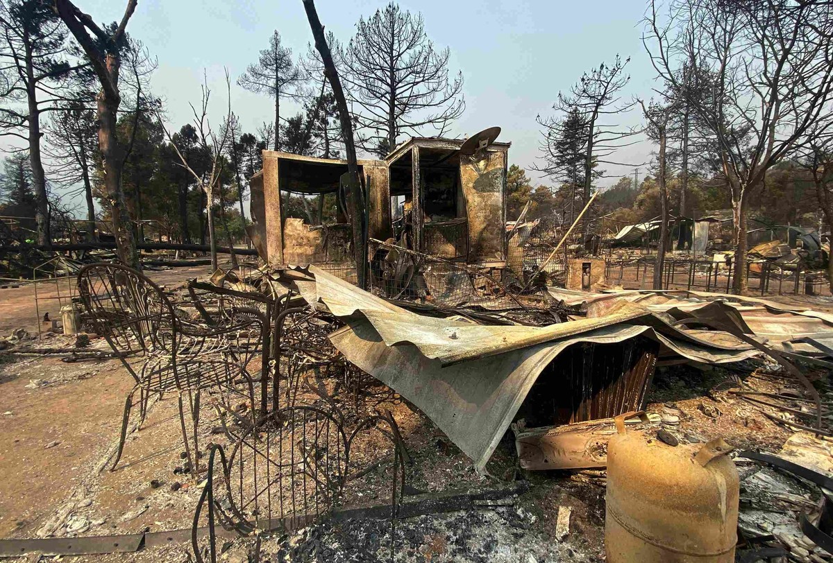 Les restes calcinés de caravanes et de tentes du camping du Pantano de Burguillo, à El Barraco, à 100 kilomètres à l'ouest de Madrid, le 27 juillet 2026. Le feu a tout ravagé.