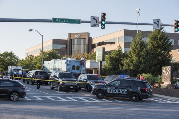 epaselect epa06848942 Police respond outside the scene of a shooting at the Capital Gazette building (seen behind) in Annapolis, Maryland, USA, 28 June 2018. Five were killed and several injured in th ...