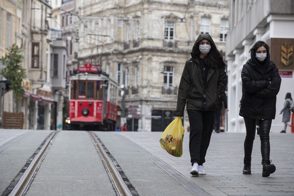 epa08324485 People with face masks walk at Istiklal Street as the city is almost deserted over coronavirus concerns, in Istanbul, Turkey, 26 March 2020. Turkish Health Minister Koca said on 25 March t ...