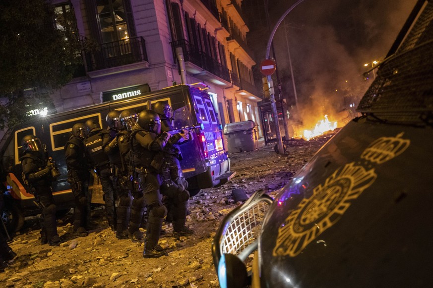 Police take position during clashes with Catalan pro-independence protestors in Barcelona, Spain, Friday, Oct. 18, 2019.The Catalan regional capital is bracing for a fifth day of protests over the con ...