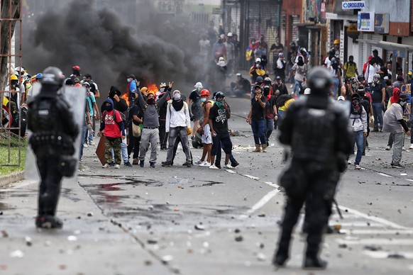 epa09355752 Demonstrators clash with members of the Mobile Anti-Riot Squad (ESMAD) of the Colombian Police at the Loma de la Cruz sector in Cali, Colombia, 20 July 2021. At least 22 people were arrest ...