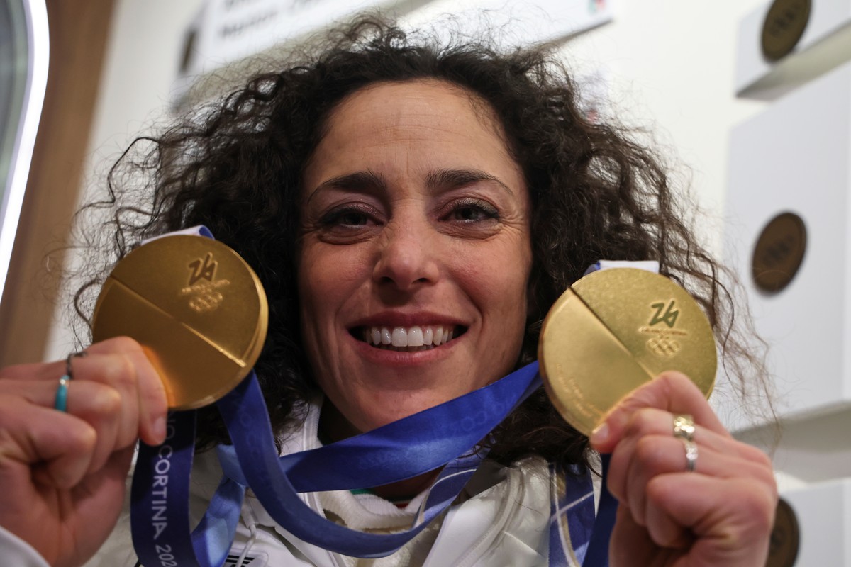 Italy's Federica Brignone shows her gold medals, one for an alpine ski, women's giant slalom race, and one for a super-G, at Casa Italia, at the 2026 Winter Olympics, in Cortina d'Ampez ...