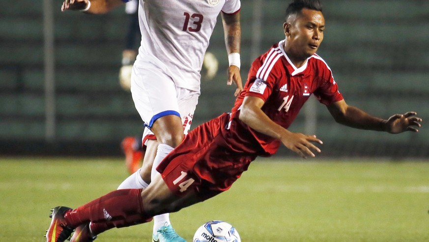 Nepal&#039;s Anjan Bista, right, falls after being fouled by Dennis Villanueva of the Philippines during their AFC Asian Cup UAE 2019 Qualifying soccer match Tuesday, March 28, 2017 at the Rizal Memor ...