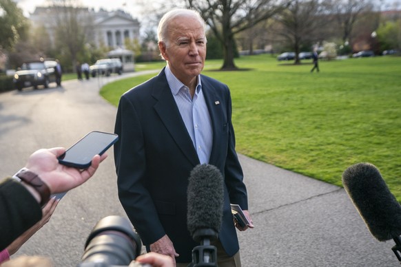 epa10552399 US President Joe Biden responds with a &#039;No comment&#039; to questions shouted to him from the news media about former President Trump&#039;s indictment as he walks to board the &#039; ...