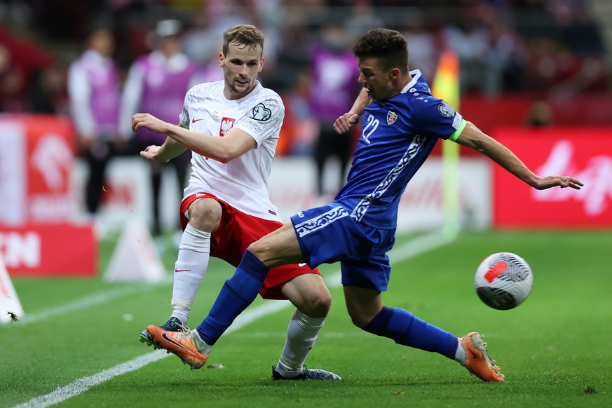 epa10921024 Tomasz Kedziora (L) of Poland in action against Vadim Rata (R) of Moldova during the UEFA European qualifying Group E soccer match between Poland and Moldova in Warsaw, Poland, 15 October  ...