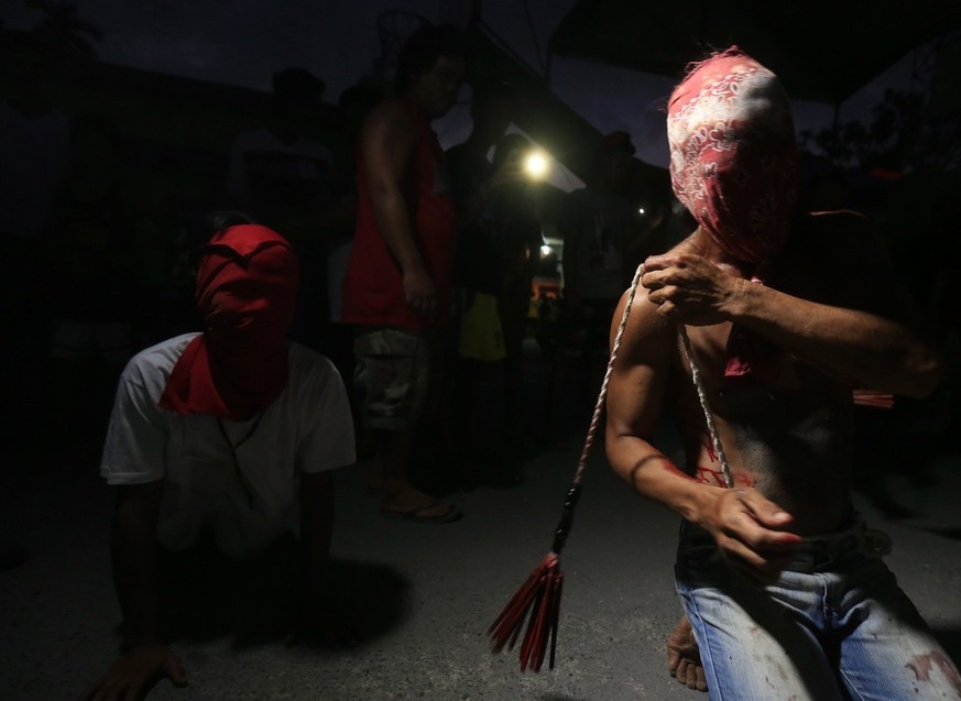 epa05228824 Filipino flagellants whip their back along a street on Maundy Thursday in the town of Paombong, Bulacan province, Philippines, 24 March 2016. On Good Friday, the village of Kapitangan will ...