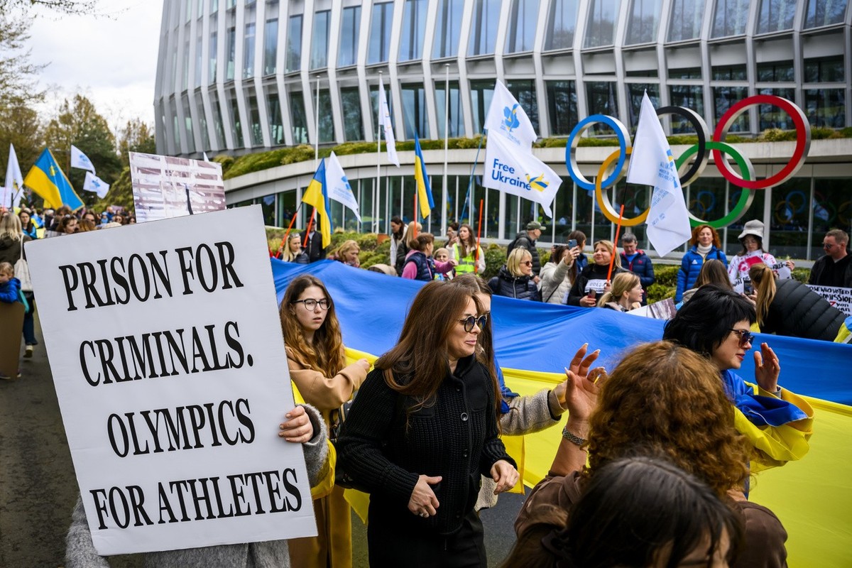 Members of the Geneva branch of Ukrainian society in Switzerland protest during a rally to urge International Olympic Committee to reconsider their decision of participation of Russian and Belarusian  ...