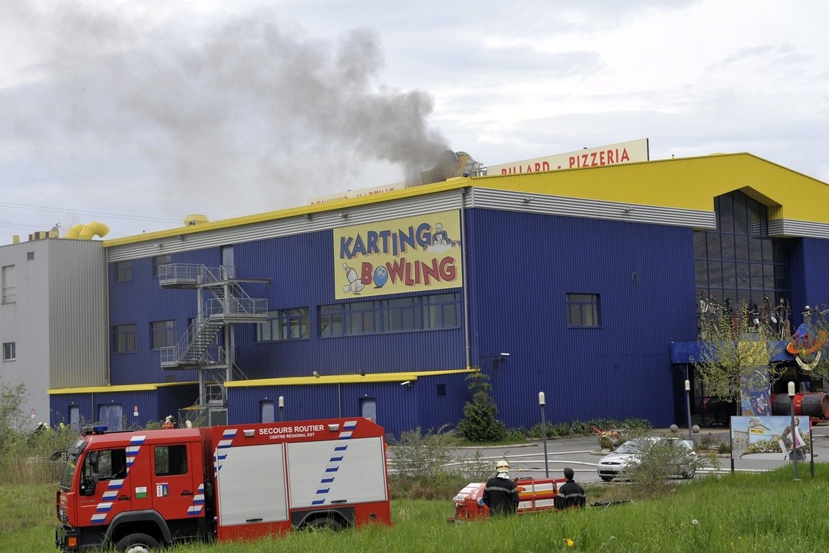 Un pompier observe la fumée qui s'échappe du batiment du complexe de loisirs Fun Planet lors de son incendie ce dimanche 26 avril 2009 a Villeneuve, Vaud. Un important incendie s'est déclaré ...
