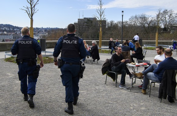 Zwei Polizisten kontrollieren, dass das Social Distancing waehrend der Coronavirus (Covid-19) Pandemie eingehalten wird, am Dienstag, 17. Maerz 2020 auf der Bundesterrasse in Bern. (KEYSTONE/Anthony A ...