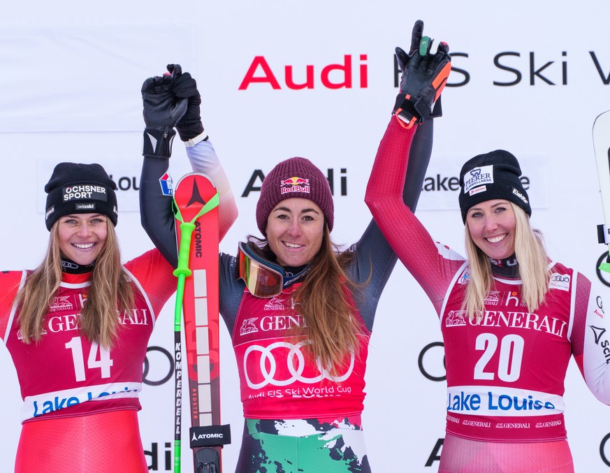 epa10345418 (L-R) second placed Corinne Suter of Switzerland, winner Sofia Goggia of Italy and third placed Cornelia Huetter of Austria celebrate on the podium after winning the Women?s Downhill race  ...