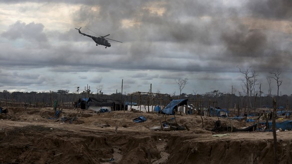 Die Polizei fliegt während einer Operation mit einem Helikopter über eine illegale Goldmine in Peru.&nbsp;
