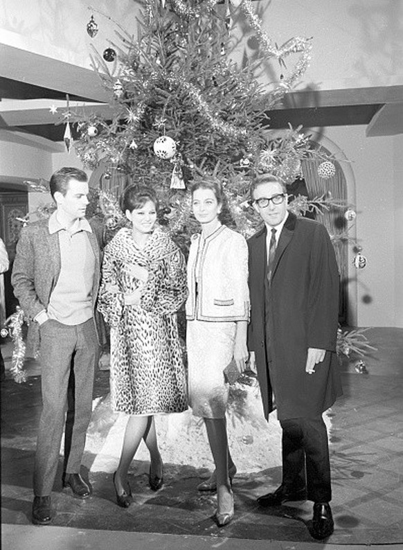 American actor Robert Wagner, British actor Peter Sellers, Italian actress Claudia Cardinale and French actress Capucine posing next to a Christmas tree during the party organized to celebrate the end ...