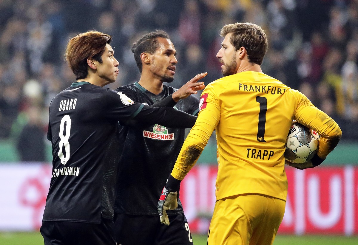 epa08270588 Bremen players Yuya Osako (L) and Theodor Gebre Selassie (C) argue with Eintracht Frankfurt's goalkeeper Kevin Trapp (R) during the German DFB Cup quarter final soccer match between E ...