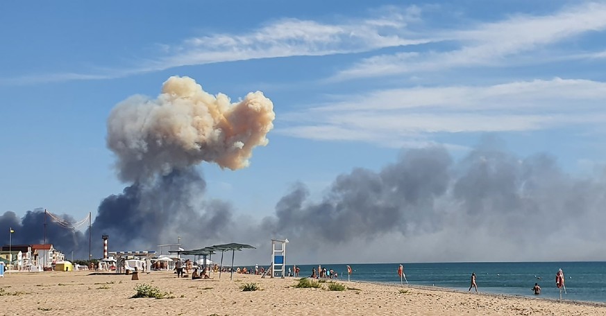 FILE - Rising smoke can be seen from the beach at Saky after explosions were heard from the direction of a Russian military airbase near Novofedorivka, Crimea, Aug. 9, 2022. More massive explosions an ...