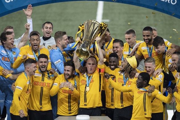 epa07600643 YB players including Steve von Bergen (C), Kevin Mbabu (R), and Loris Benito (L) celebrate their championship title after the Swiss Super League soccer match between the Bernese Young Boys ...