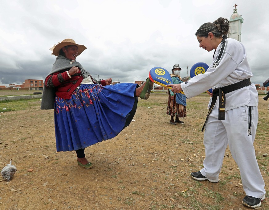 epa09793982 Bolivian Laura Roca (R) from Warmi Power, conducts a self-defense workshop in the Villa Mercedes neighborhood in El Alto, Bolivia, 18 February 2022 (Issued 01 March 2022). Taekwondo techni ...