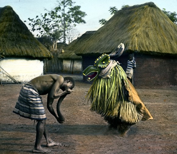«Fetischtanz» in&nbsp;Assinie, Elfenbeinküste in Westafrika, 1933. Man beachte den Jungen im Hintergrund in europäischer Kleidung.