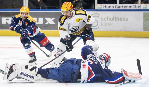 Ambris Matt D&#039;Agostini, oben, kaempft um den Puck gegen Zuerichs Torhueter Lukas Flueeler, unten, im Eishockeyspiel der National League zwischen den ZSC Lions und dem HC Ambri-Piotta am Freitag,  ...