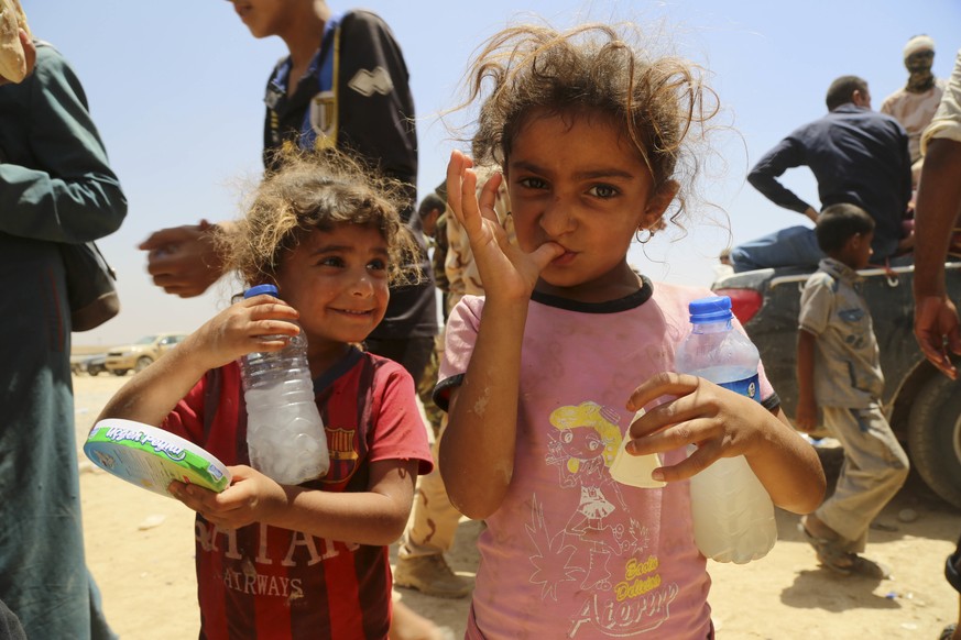 In this Friday, July 15, 2016 picture, two girls and other displaced civilians, who fled their Islamic State-held towns and villages south of Mosul during fight between Iraqi security forces and Islam ...