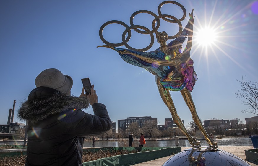 Eine Passantin fotografiert in Peking eine Statue für die olympischen Winterspiele.