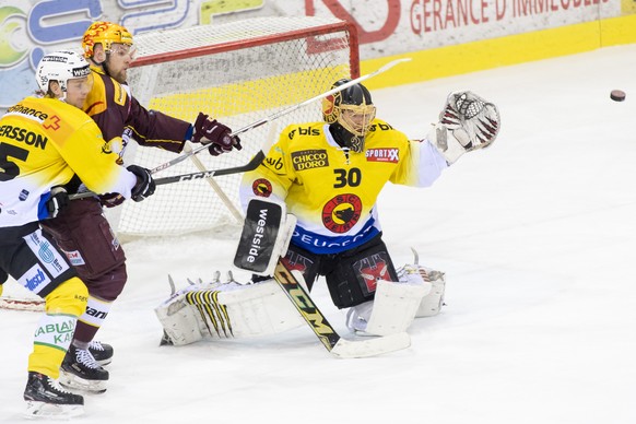 Bern&#039;s defender Calle Andersson of Sweden, left, and Bern&#039;s goaltender Leonardo Genoni, right, vie for the puck against Geneve-Servette&#039;s Top Scorer Tanner Richard, center, during the f ...