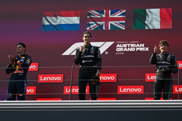 Race winner Mercedes driver George Russell of Britain, center, stands on the podium with second placed Red Bull driver Max Verstappen of the Netherlands, left, and third placed Mercedes driver Andrea  ...