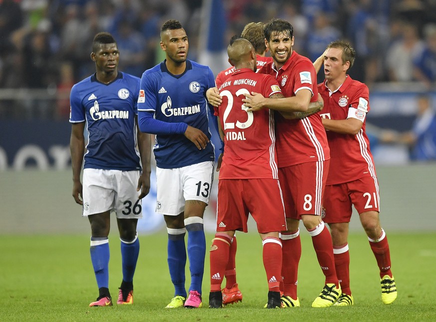 Schalke&#039;s Breel Embolo and Eric Maxim Choupo-Moting, left, watching celebrating Bayern players after the German Bundesliga soccer match between FC Schalke 04 and Bayern Munich in Gelsenkirchen, G ...