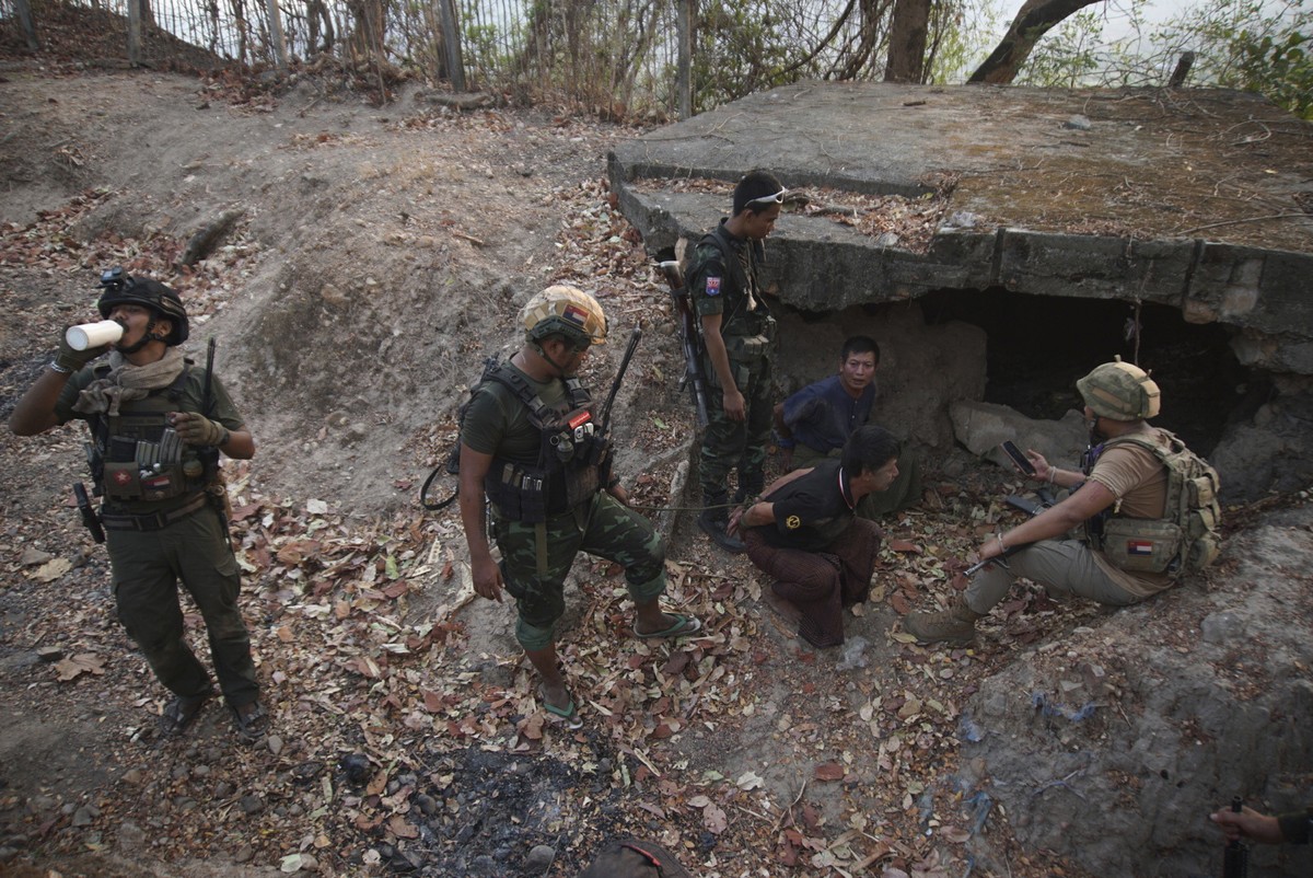 FILE - Members of the Karen National Liberation Army and People's Defense Force examine two arrested soldiers after they captured an army outpost, in the southern part of Myawaddy township in Kay ...