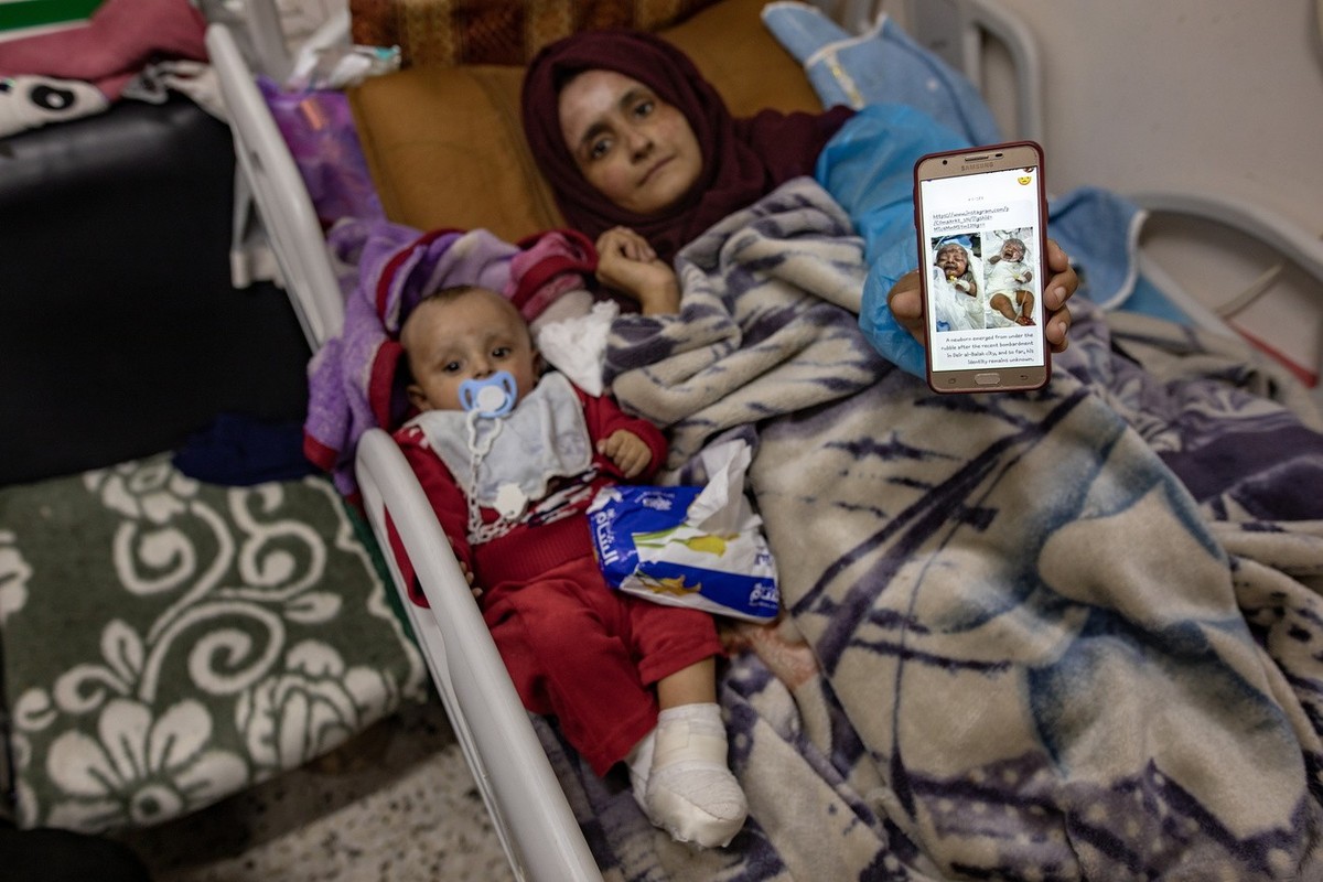 epa11072029 Palestinian, 23 years old Raneen Annaba shows a photo on her mobile depicting her five months old son Sanad Baraka on the day he had been found injured with a message in english explaining ...