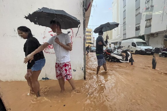 epa12416591 People walk along flooded streets in Ibiza, Spain, 30 September 2025, after heavy rains that have caused several floods throughout the island. Spain&#039;s State Meteorological Agency (Aem ...