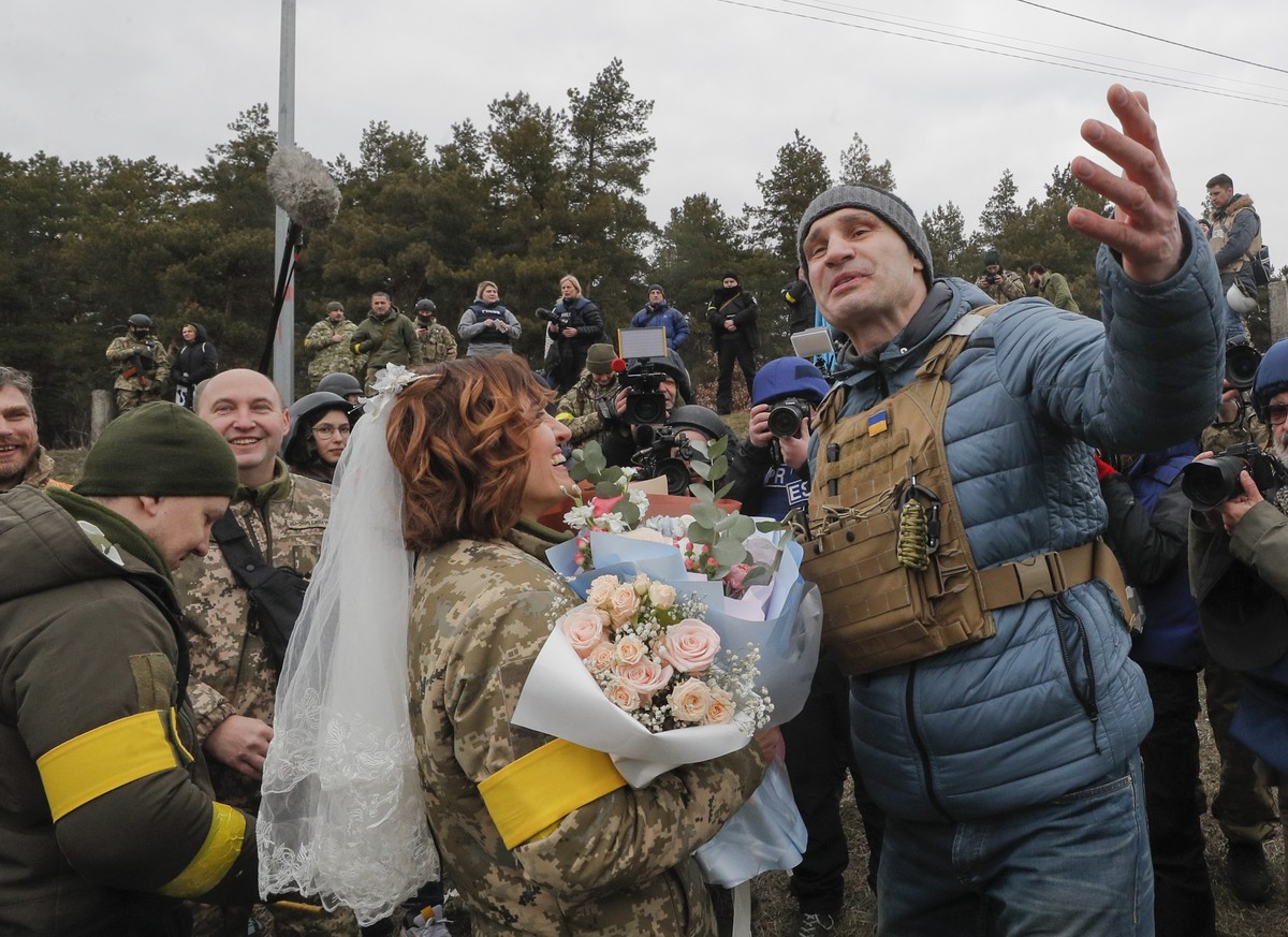 epa09805698 Kiev's Mayor Vitaly Klitschko (R) greets Ukrainian territorial defense fighter Lesya following her wedding with Valeriy (L) at a blockpost near Kyiv (Kiev), Ukraine, 06 March 2022. Ru ...