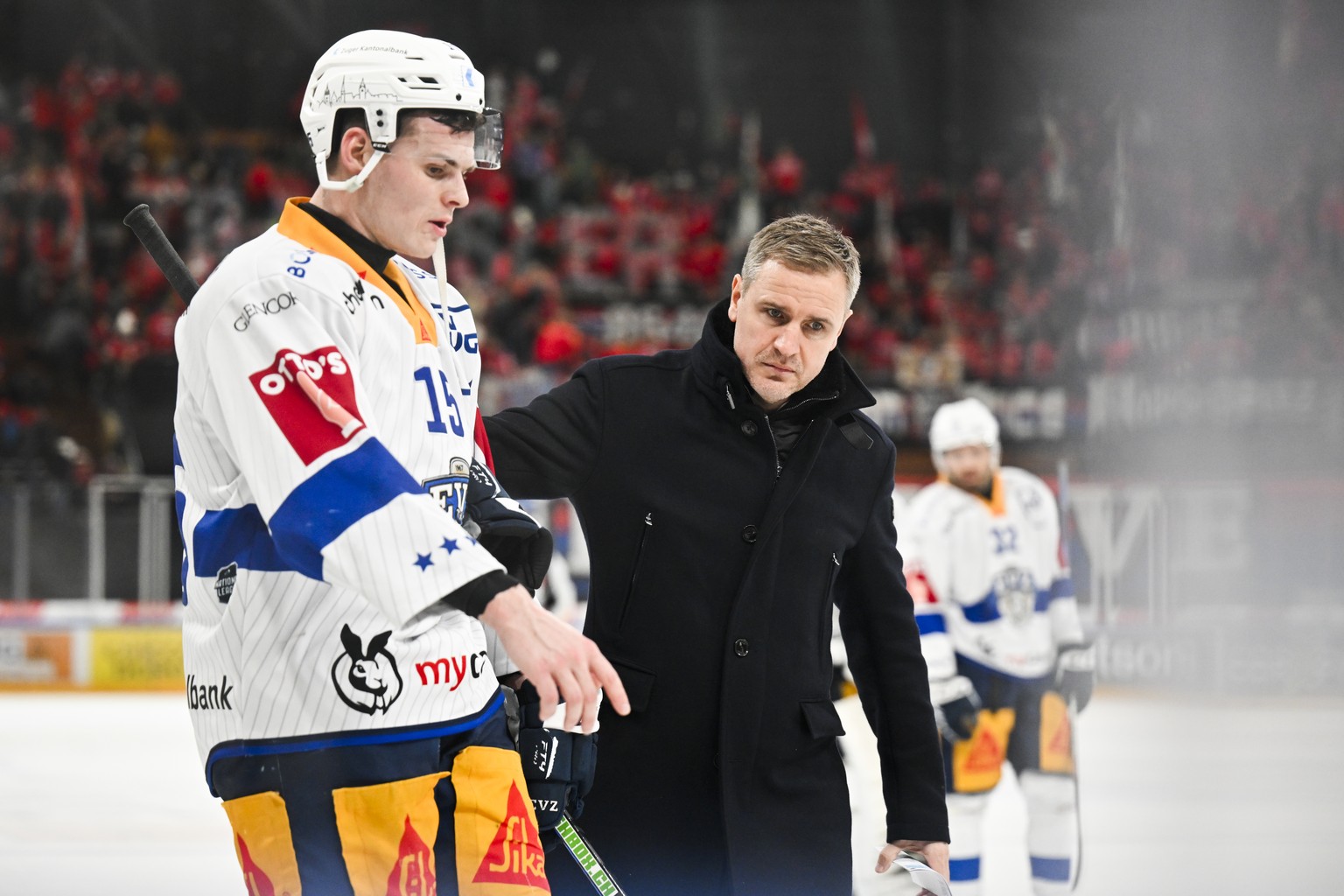 Der Zuger Trainer Dan Tangnes, Mitte, spricht mit Gregory Hofmann, im Eishockeyspiel der National League zwischen den Rapperswil-Jona Lakers und dem EV Zug, am Samstag, 3. Februar 2024, in der St. Gal ...