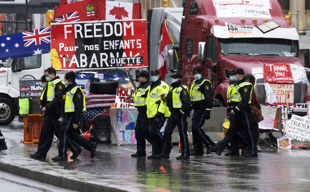 Ontario Provincial Police officers walk in front of the ongoing trucker blockade protest in Ottawa, Thursday, Feb. 17, 2022. Hundreds of truckers clogging the streets of Canada's capital city in  ...
