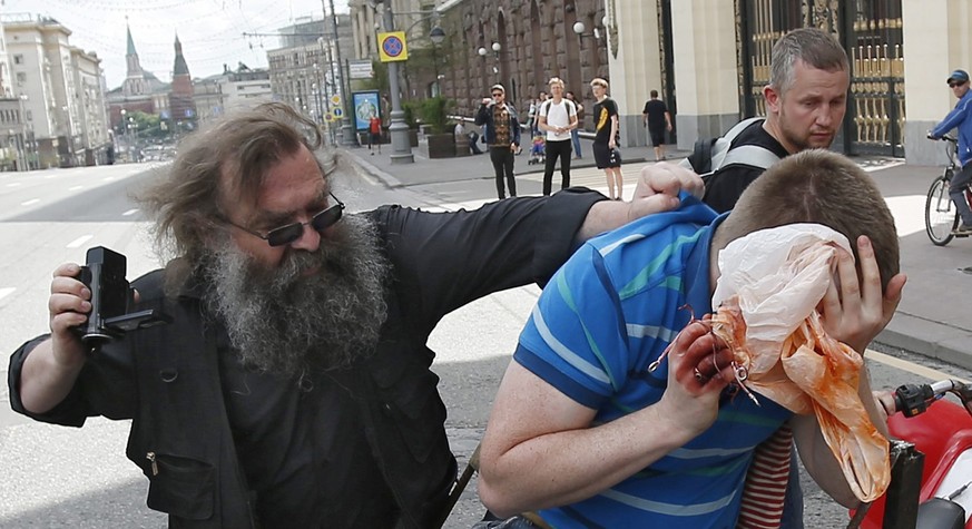 epa04775272 A Russian man clashes with Nikolai Alexeyev (C), an activist of the LGBT (lesbian, gay, bisexual, and transgender) community, who was trying to participate in a rally in front of the Mosco ...