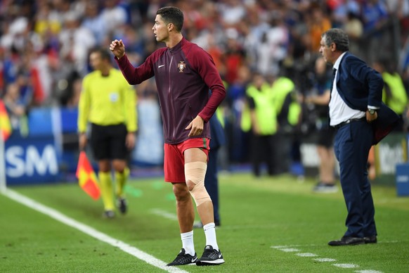 epa05419596 Cristiano Ronaldo of Portugal stands by the sideline during the UEFA EURO 2016 Final match between Portugal and France at Stade de France in Saint-Denis, France, 10 July 2016. 


(RESTR ...