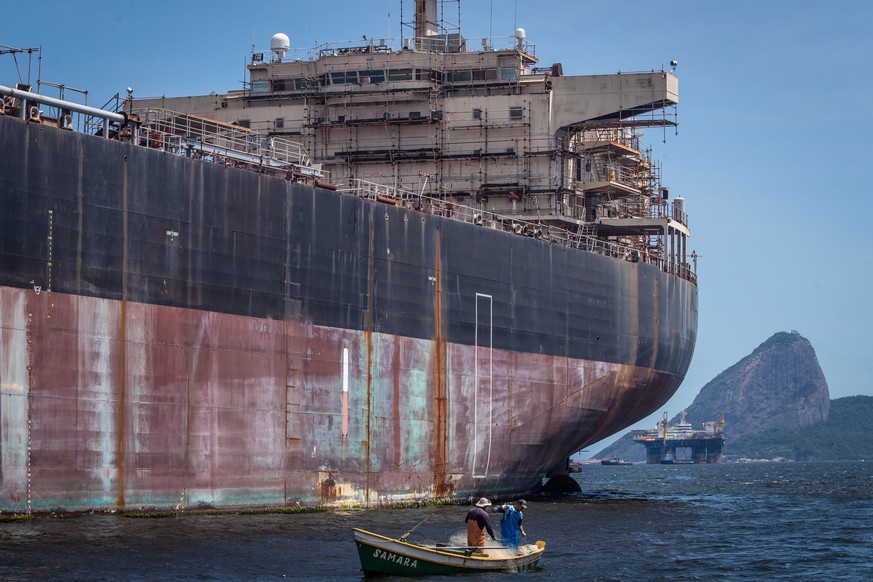 epa10334136 Fishermen work next to an oil tanker in Guanabara Bay, in Niteroi, near Rio de Janeiro, Brazil, on 21 November 2022 (issued 28 November 2022). The Guanabara Bay, which bathes Rio de Janeir ...