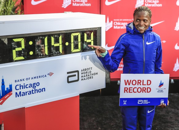 epa07918570 Brigid Kosgei of Kenya poses after setting a new women world record time of 02:14:04 in the 2019 Chicago Marathon in Chicago, Illinois, USA, 13 October 2019. The Chicago Marathon, first ru ...