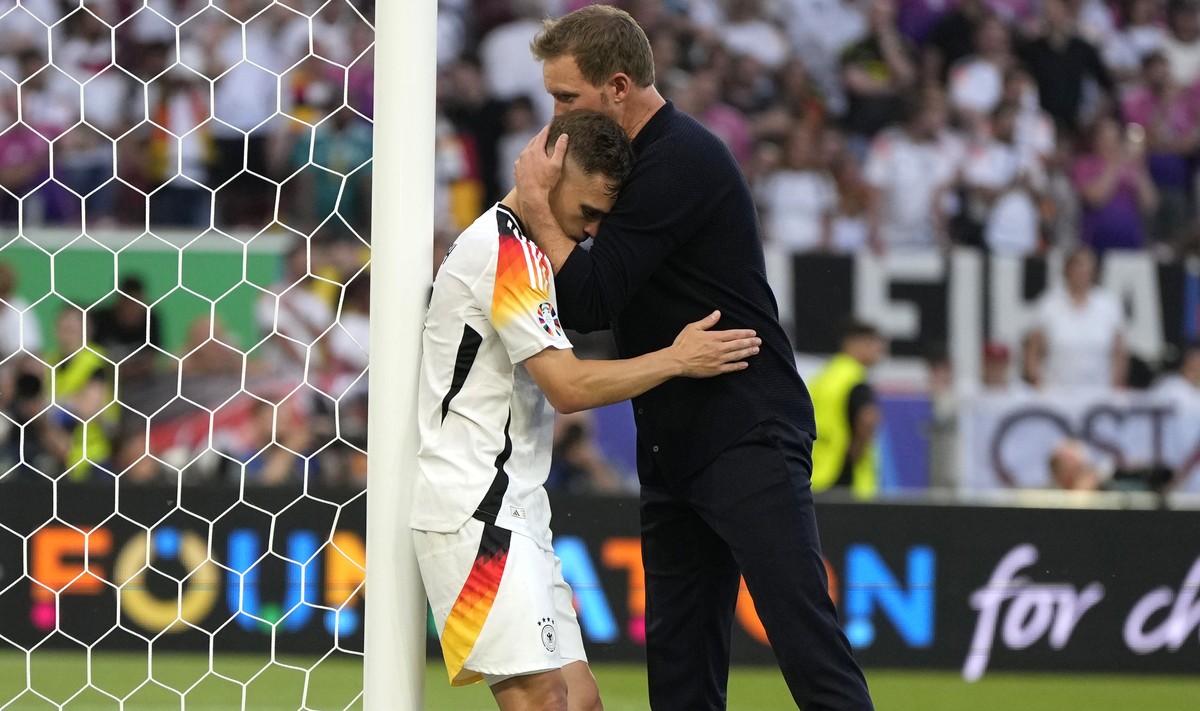Germany's Joshua Kimmich is hugged by Germany's head coach Julian Nagelsmann at the end of a quarter final match between Germany and Spain at the Euro 2024 soccer tournament in Stuttgart, Ge ...