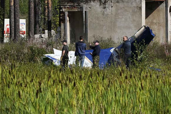 Russian servicemen inspect a part of a crashed private jet near the village of Kuzhenkino, Tver region, Russia, Thursday, Aug. 24, 2023. Russian mercenary leader Yevgeny Prigozhin, the founder of the  ...