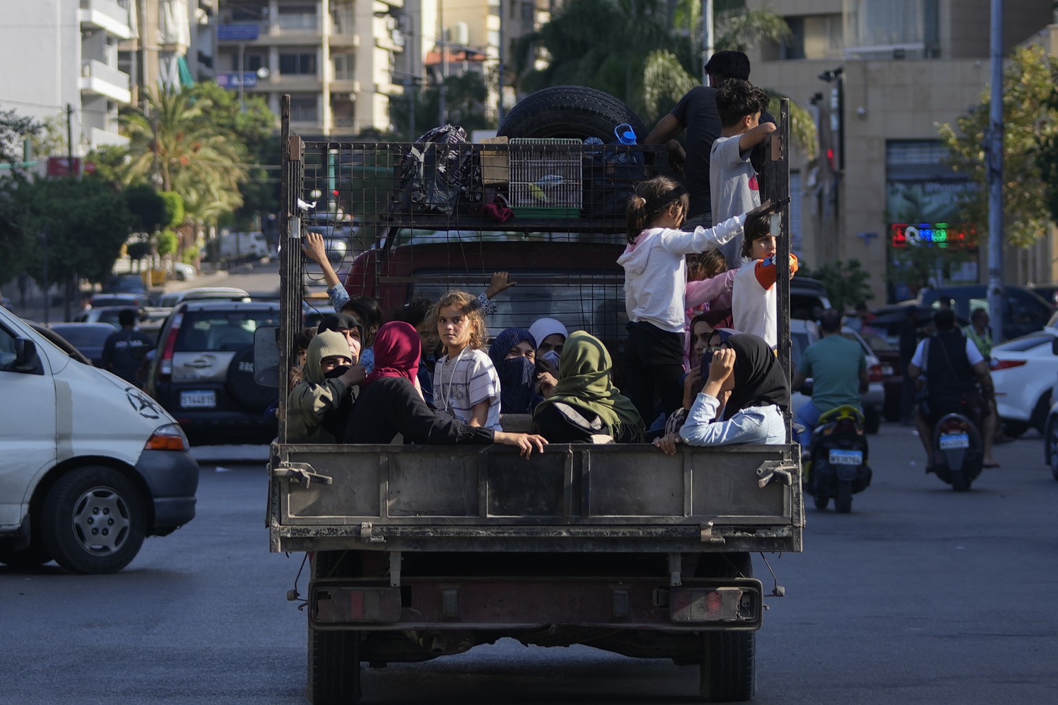Lebanese citizens who fled from the southern villages amid ongoing Israeli airstrikes Monday, sit in a pickup in Beirut, Tuesday, Sept. 24, 2024. (AP Photo/Hassan Ammar)