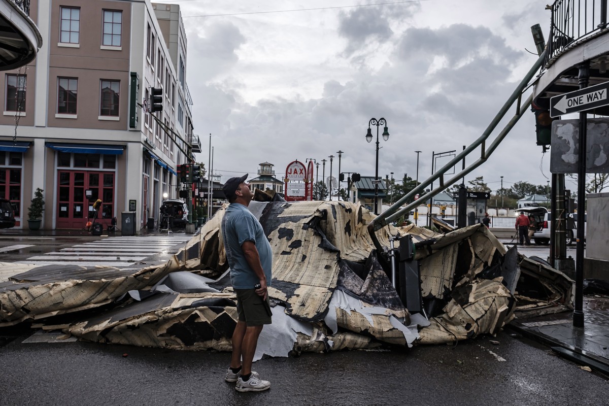 epa09623673 A man looks up next to a chunk of roof that ripped off a building in the French Quarter due to Hurricane Ida in New Orleans, Louisiana, USA, 30 August 2021. Hurricane Ida made landfall on  ...